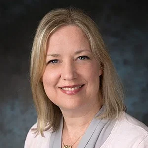 Portrait of a professional woman with blonde hair smiling for Client Stories.