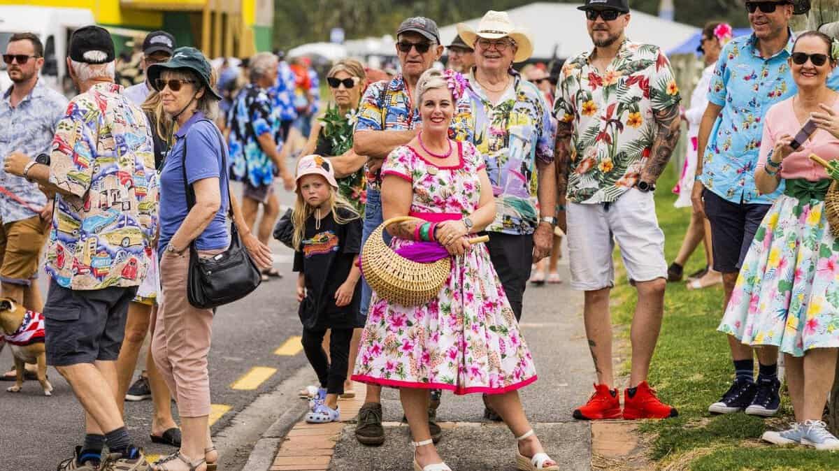 Colourful crowd at Americarna car festival in New Zealand, showcasing vintage cars and retro fashion.