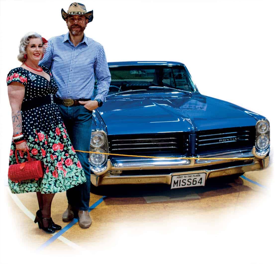 Classic American muscle car with vintage style and retro fashion enthusiasts at Americarna event in New Zealand.