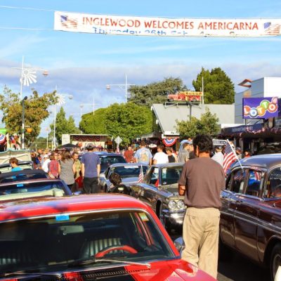 Vibrant Americarna classic car show in Inglewood New Zealand with vintage vehicles and enthusiastic crowd.