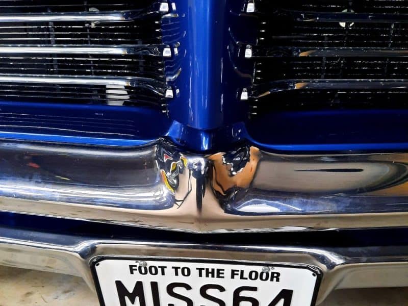 Shiny blue vintage car front with chrome details and Miss 64 NZ license plate.
