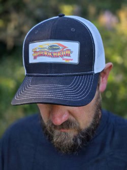 Man wearing a blue and white truck logo cap with "Hot Rod America" embroidered, outdoors in natural light.