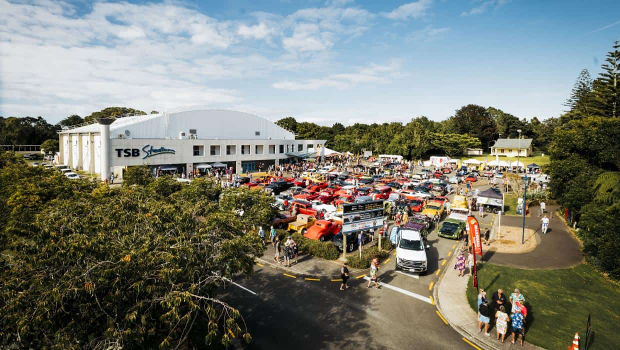 Large outdoor car show with vintage and classic cars at Americarna event.
