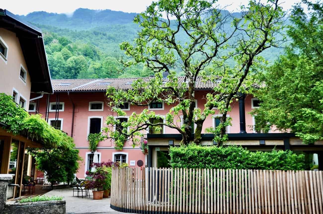 a pink building with a fence and trees in the background