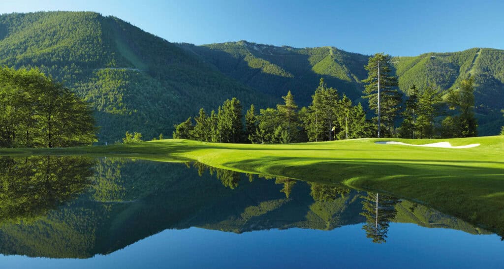 Scenic golf course with mountain reflection