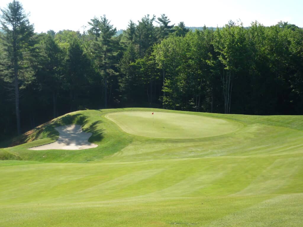 Lush green golf course with sand trap