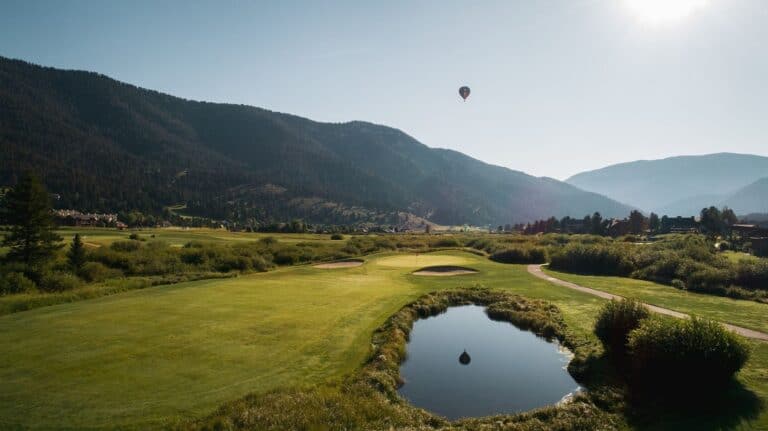 Golf course with mountains and balloon