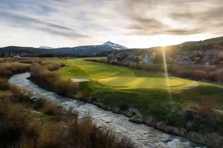 Scenic golf course with mountains and stream