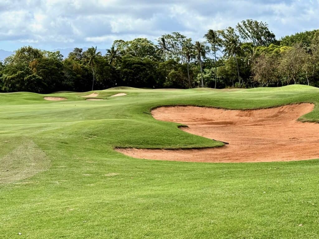 Lush green golf course with sand trap