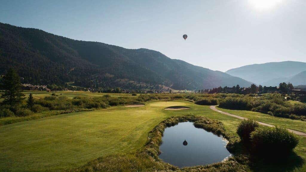 Golf course with mountains and balloon