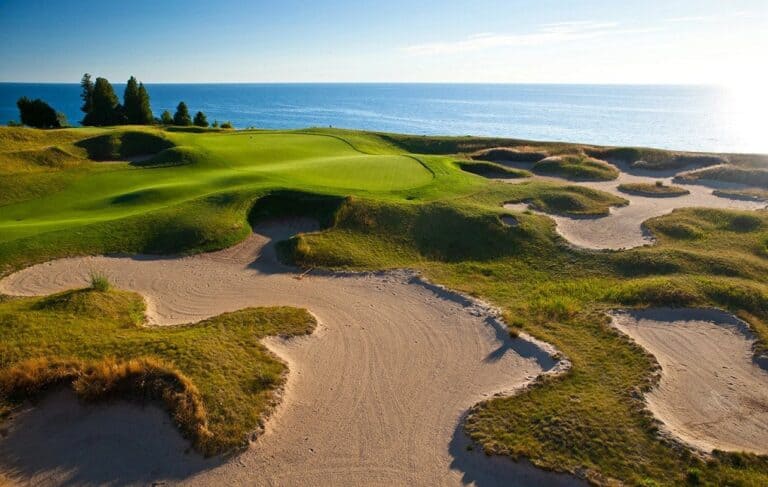 Coastal golf course with sandy bunkers.