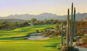 Desert golf course with cacti and mountains
