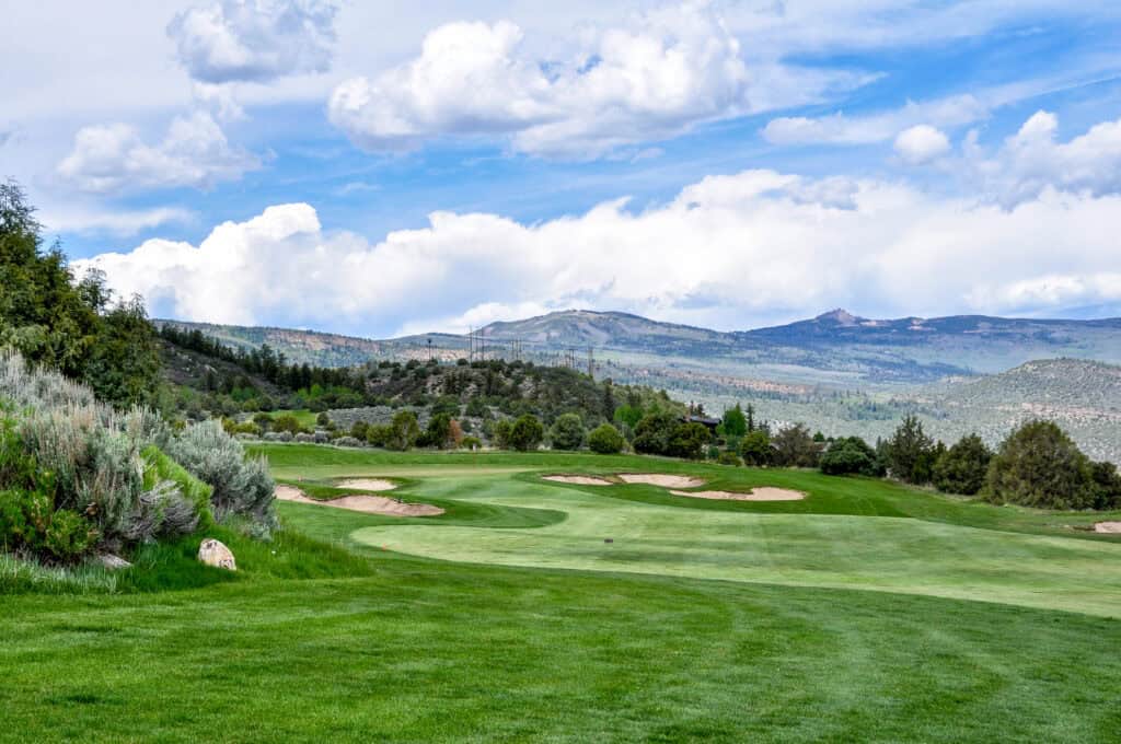 Scenic golf course with rolling hills and blue sky for mindful walking practice.