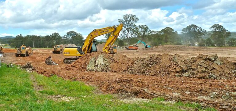 Machinerie de construction sur un site d'enfouissement, excavation de terrain pour projet immobilier ou infrastructure, équipe de travaux publics.