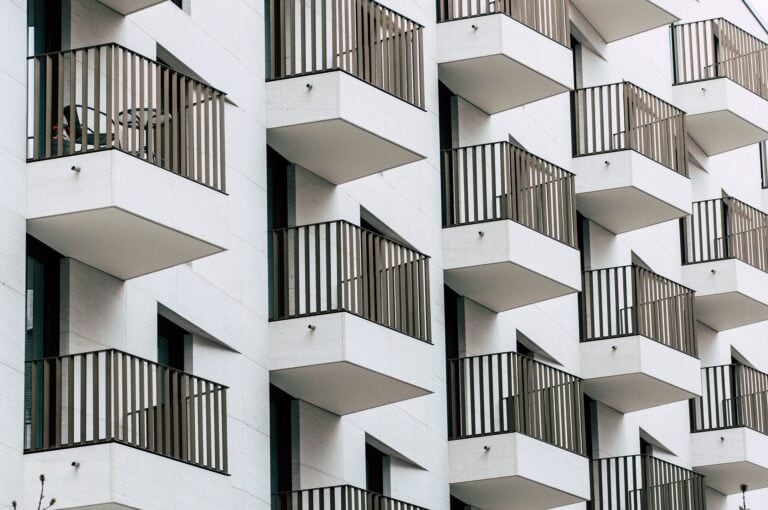 Balcon d'immeuble moderne avec garde-corps en bois, architecture contemporaine, bâtiments résidentiels de style urbain, design minimaliste, logement en ville à Montréal.