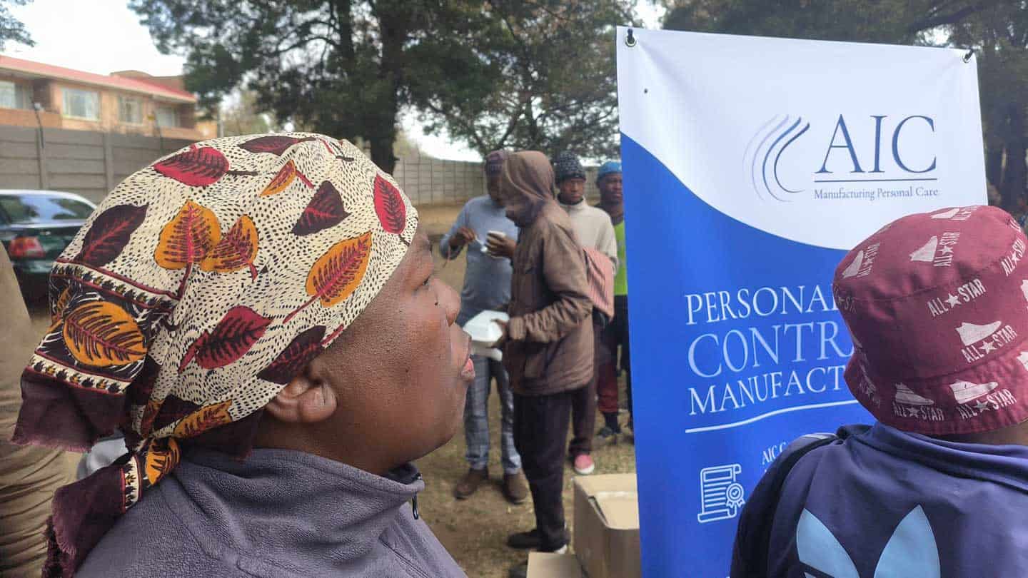 AIC manufacturing training centre banner at outdoor event in Africa.
