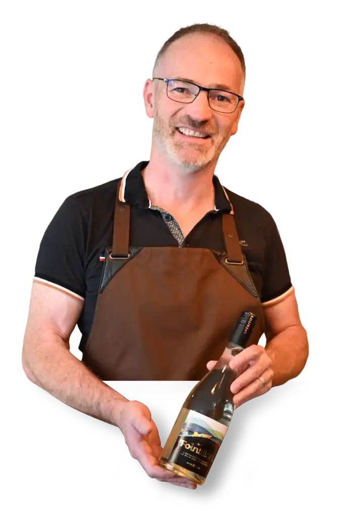 Dégustation d'un apéritif insolite avec un homme souriant portant un tablier, présentant une bouteil.
