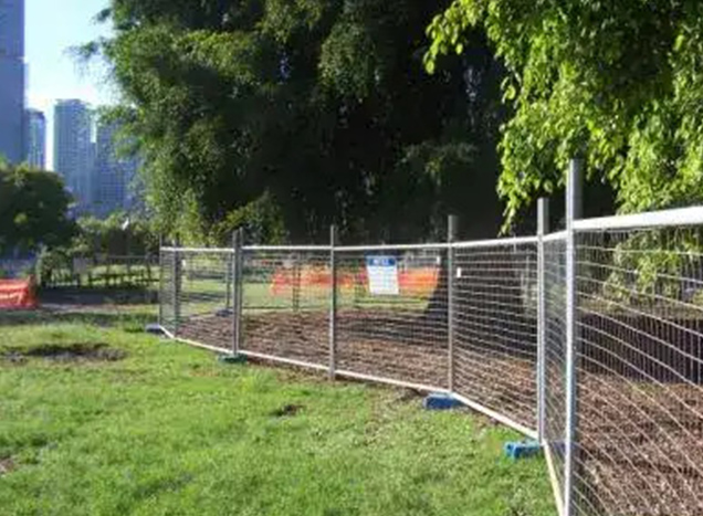 Temporary fencing installed in a park for construction safety.