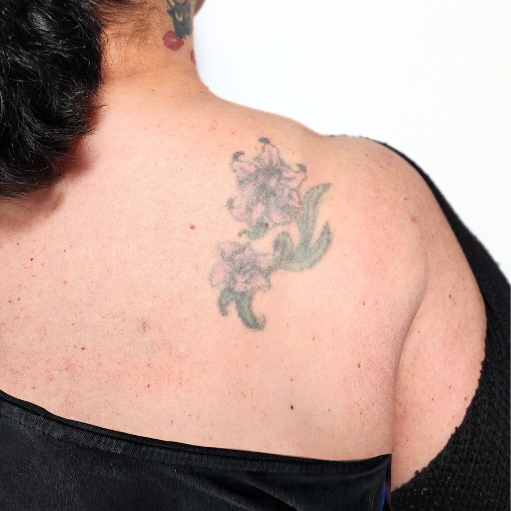 Verblasstes Blumentattoo auf Schulter vor Cover-Up