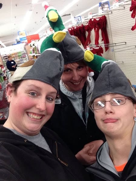 Two females and a young boy at a store taking a silly selfie with duck hats. 