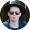 Person in a black hat and sunglasses looking forward