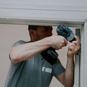 Man using a power drill to install a door frame