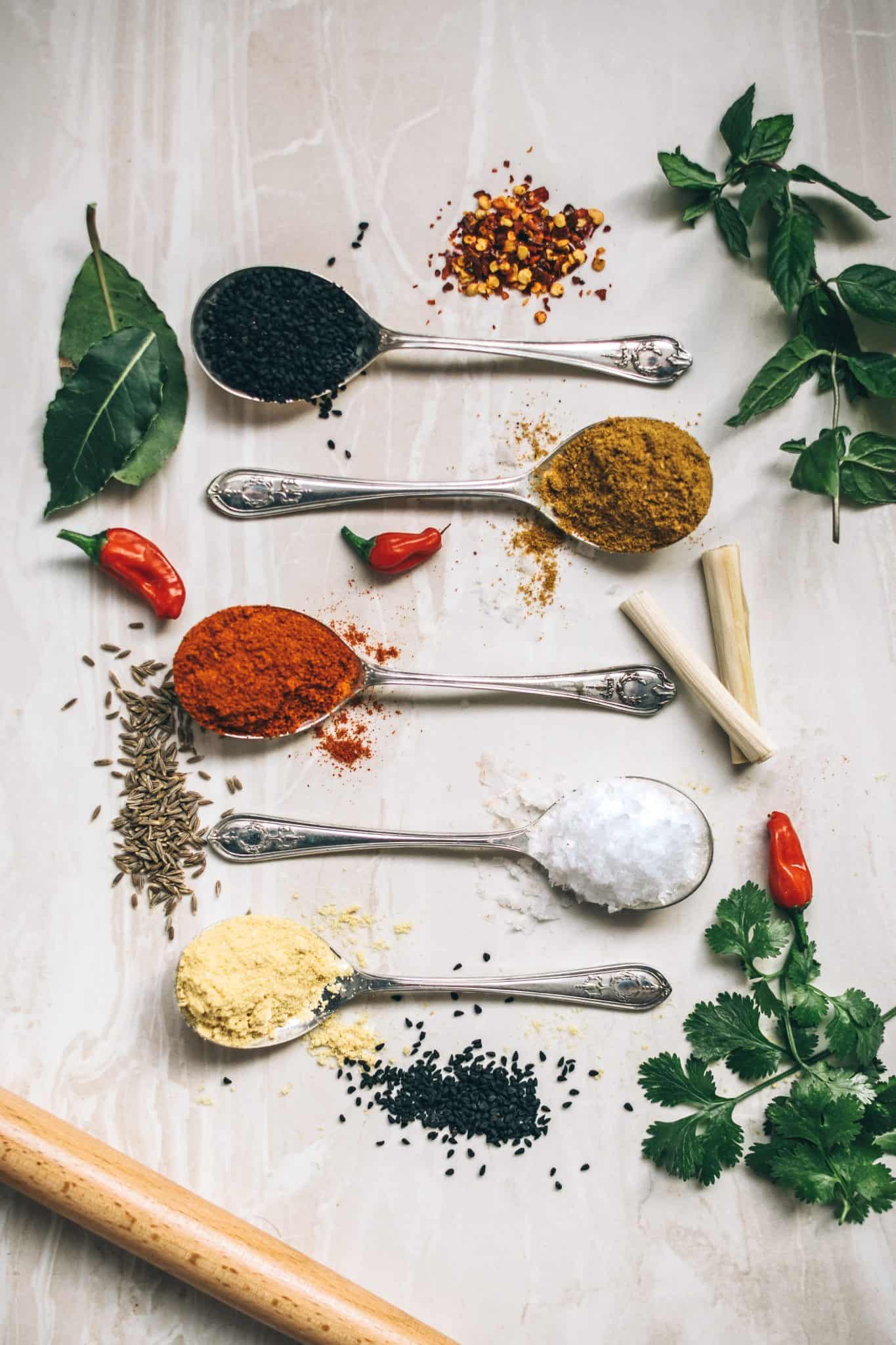 Metal spoons full of spices and salt