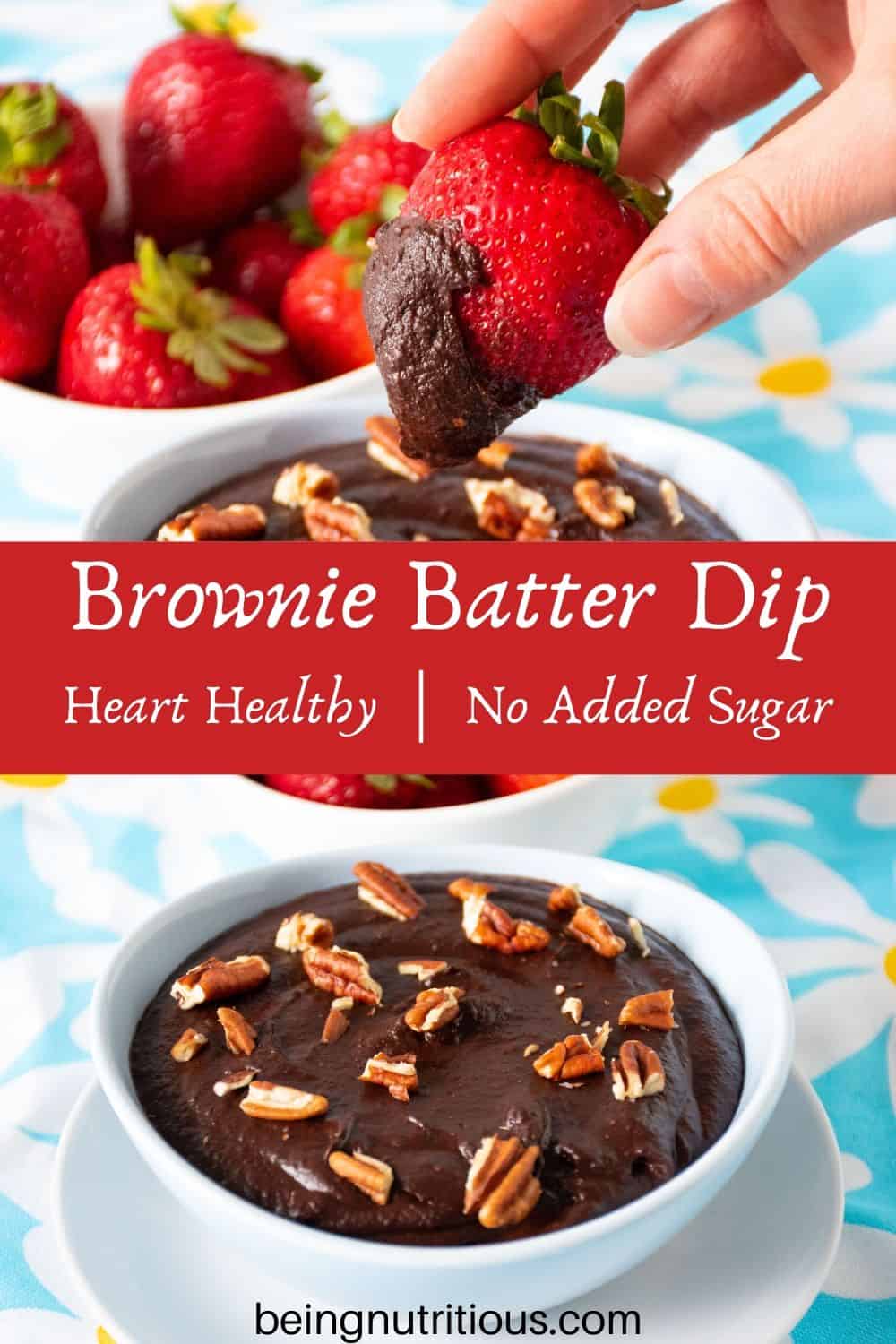 Brownie batter dip in a bowl with a bowl of strawberries behind. A hand holding a strawberry with dip on it in the foreground.