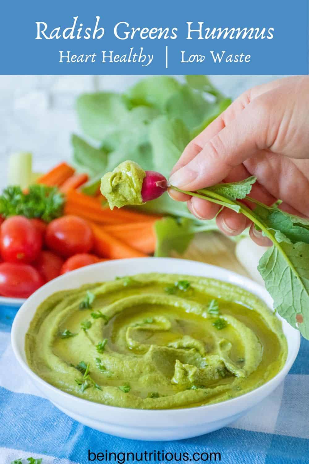 Radish greens hummus in a white bowl, with a radish being dipped in.