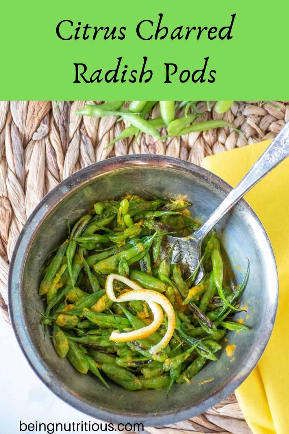 Overhead shot of charred radish pods and orange peel garnish in a silver bowl with a silver fork and text overlay: "Citrus Charred Radish Pods"
