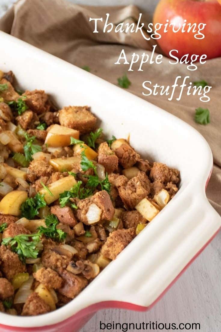 Stuffing in a large casserole dish. Whole apples visible in background. Text overlay: Thanksgiving apple sage stuffing.