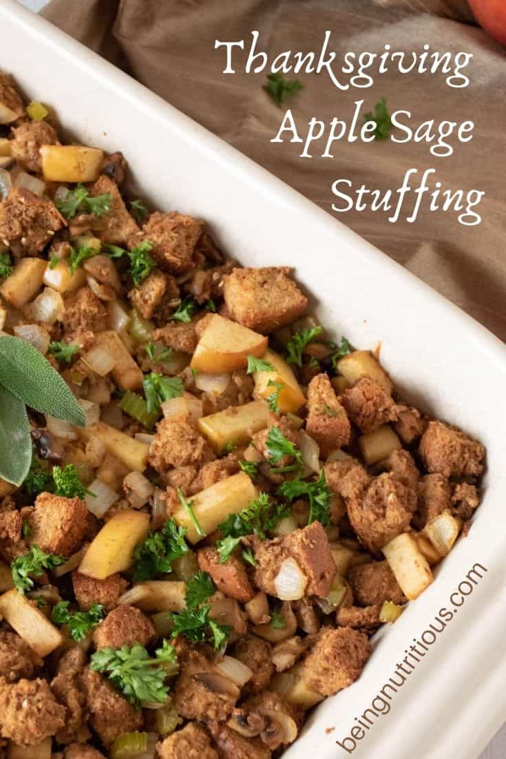Close up of stuffing, garnished with 2 fresh sage leaves. Text overlay: Thanksgiving apple sage stuffing.