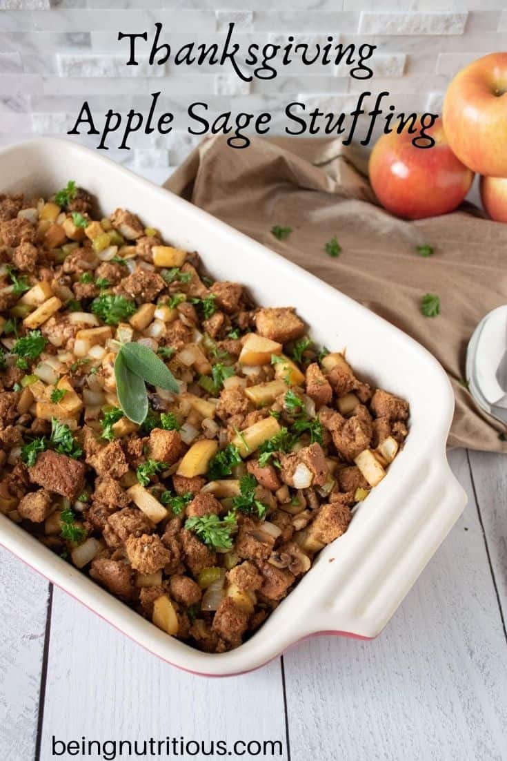Stuffing in a large casserole dish. Apples visible in background. Text overlay: Thanksgiving apple sage stuffing.
