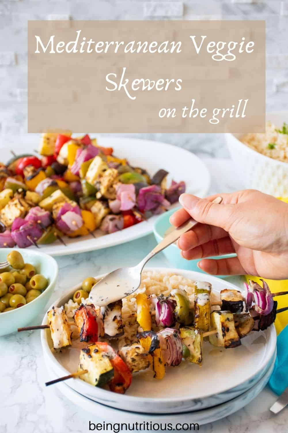 Plate with 2 veggie skewers and rice, with marinade being drizzled over. Text overlay: Mediterranean Veggie Skewers on the grill.