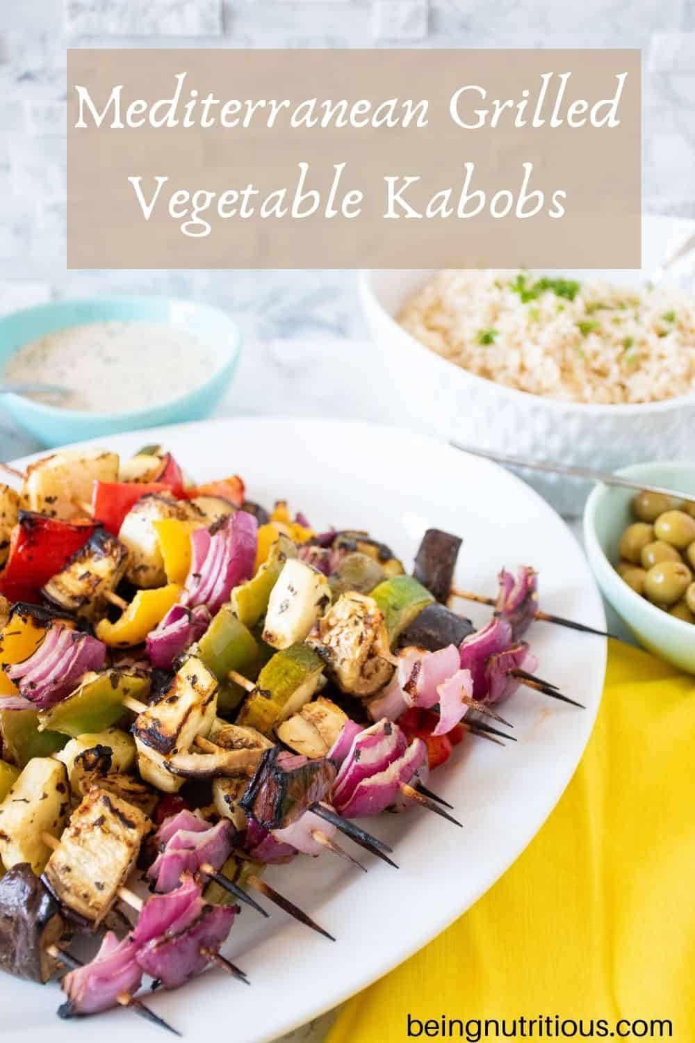 Serving platter with vegetable skewers piled on. Text overlay: Mediterranean Grilled Vegetable Kabobs.