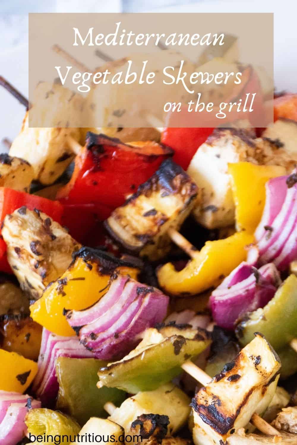 Close up of vegetable kabobs. Text overlay: Mediterranean Vegetable Skewers on the grill.