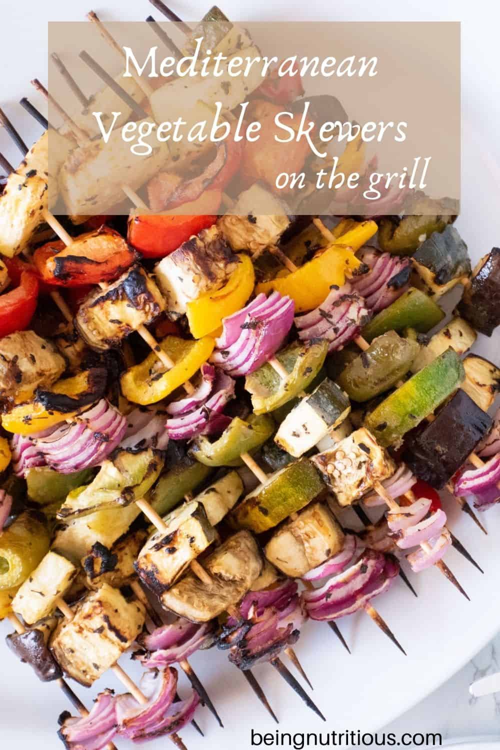 Serving platter with vegetable skewers piled on. Text overlay: Mediterranean Vegetable Skewers on the Grill.