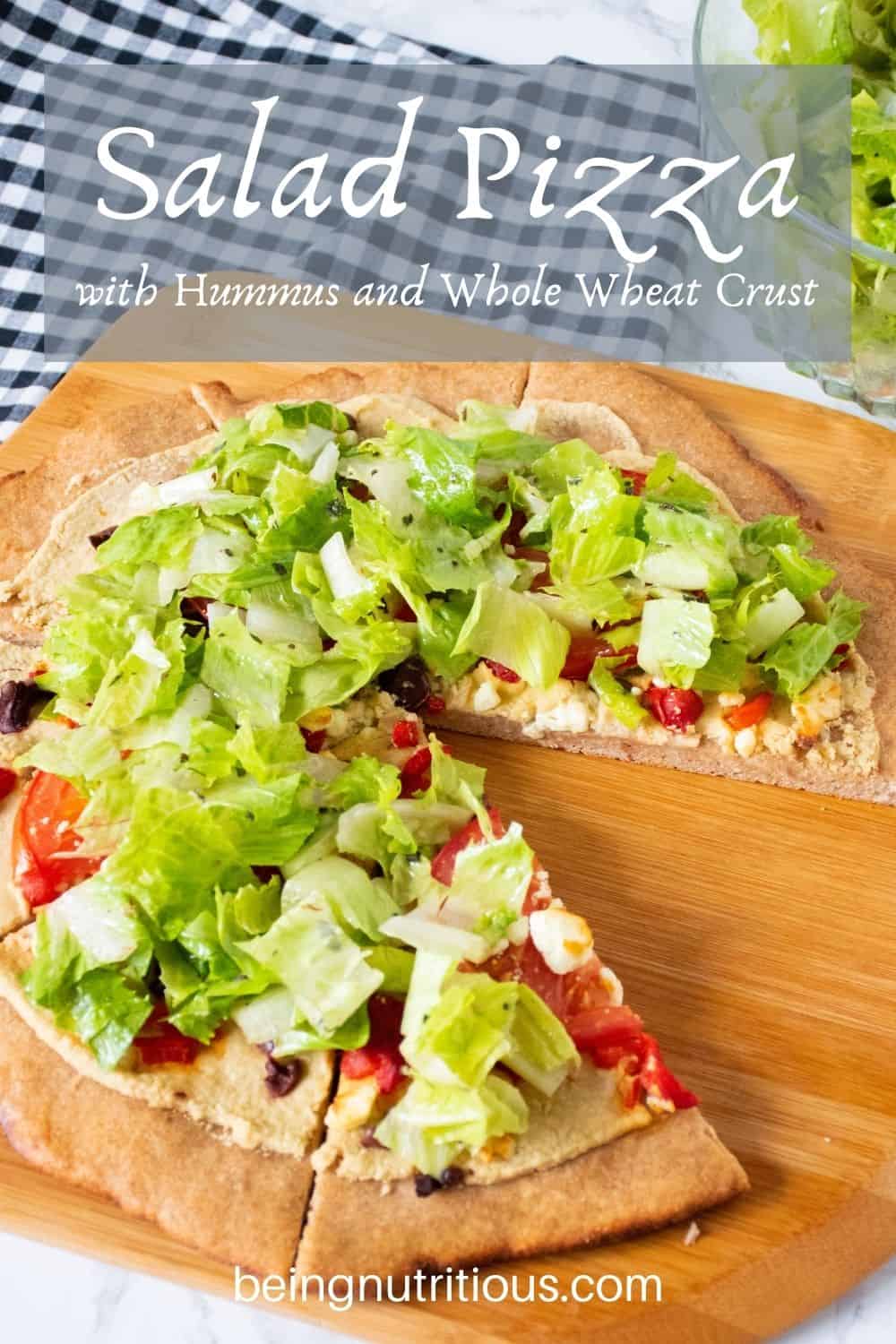Pizza on a peel, with whole wheat crust, topped with salad. Text overlay: Salad Pizza with Hummus and Whole Wheat Crust.