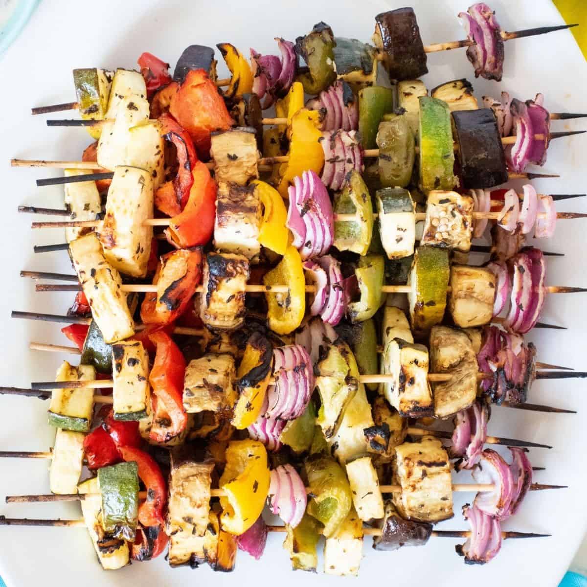Serving platter with vegetable skewers piled on.