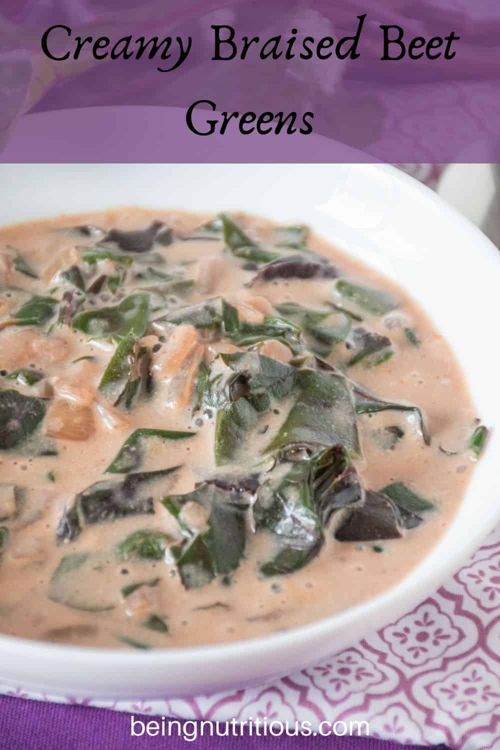 Close up of a bowl of braised greens in a light pink broth. Text overlay: Creamy Braised Beet Greens.