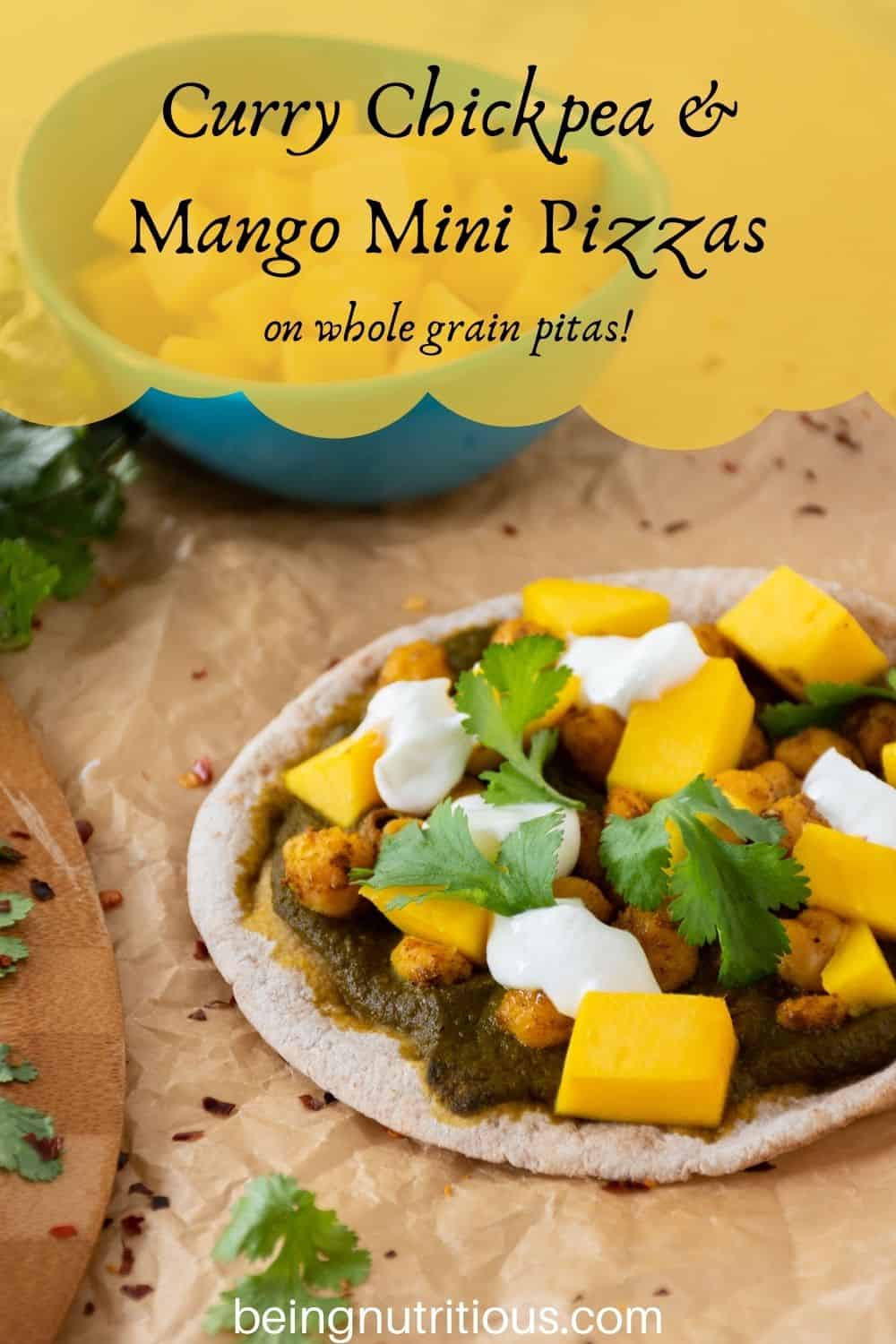 pizza with spinach sauce, chickpeas, and mangoes on a mini pita. Text overlay: Curry Chickpea & mango mini pizzas; on whole grain pitas!
