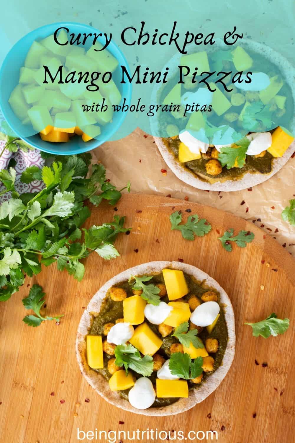 overhead shot of pizza with spinach sauce, chickpeas, and mangoes on a mini pita. Text overlay: Curry Chickpea & mango mini pizzas; with whole grain pitas.