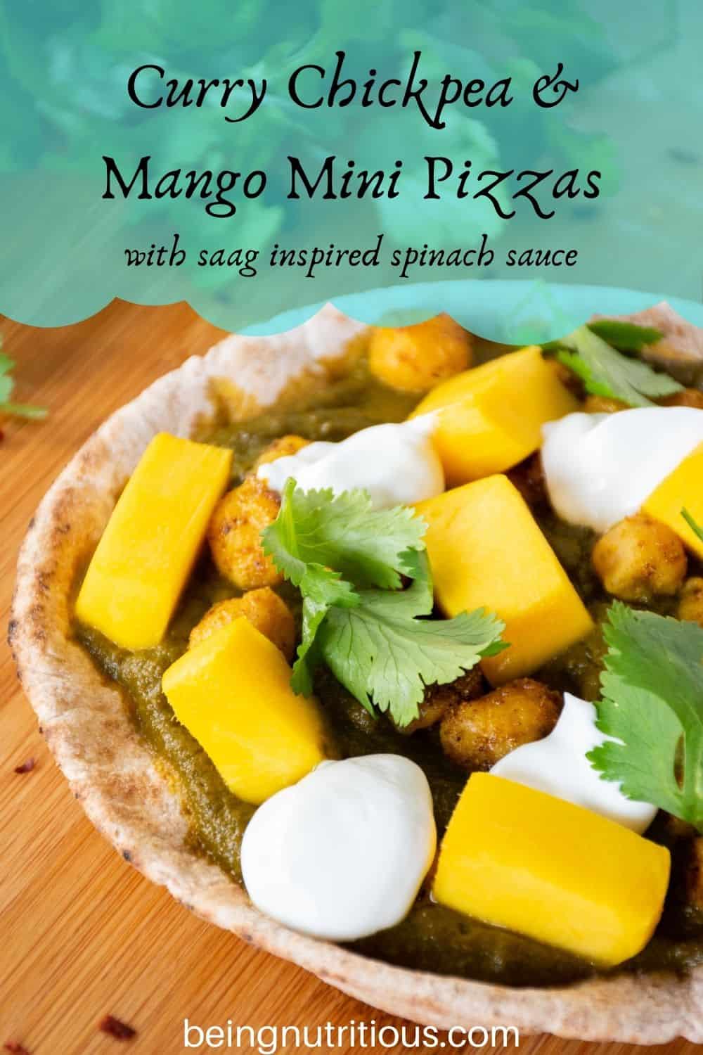pizza with spinach sauce, chickpeas, and mangoes on a mini pita. Text overlay: Curry Chickpea & mango mini pizzas; with saag inspired spinach sauce.
