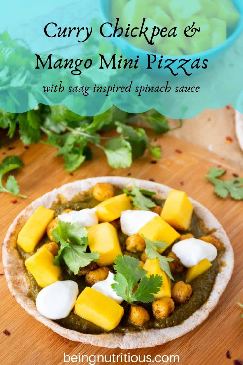 pizza with spinach sauce, chickpeas, and mangoes on a mini pita. Text overlay: Curry Chickpea & mango mini pizzas; with saag inspired spinach sauce.