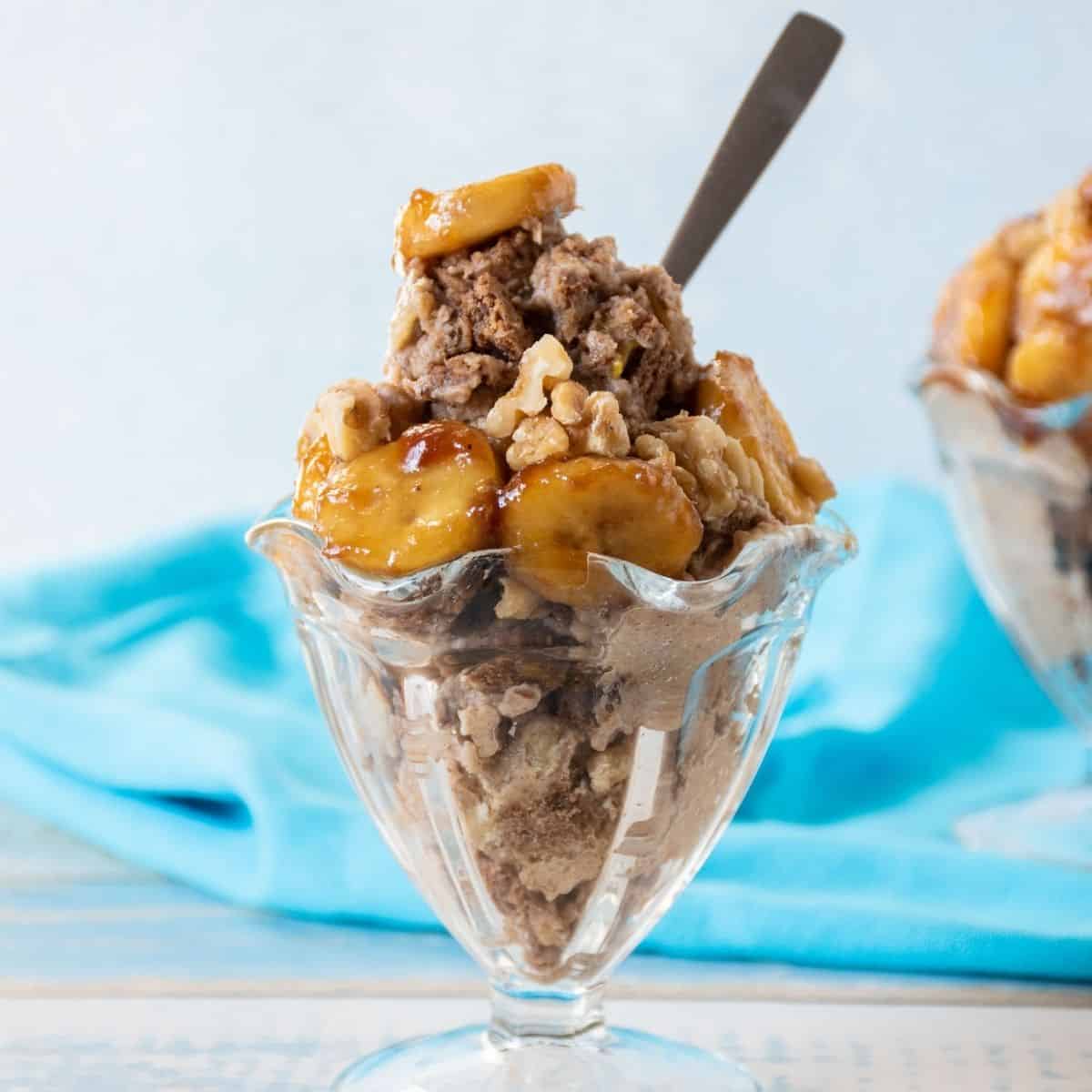 Sundae dish with nice cream topped with caramelized bananas and walnuts