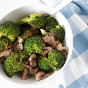 Roasted broccoli and mushrooms in a bowl.