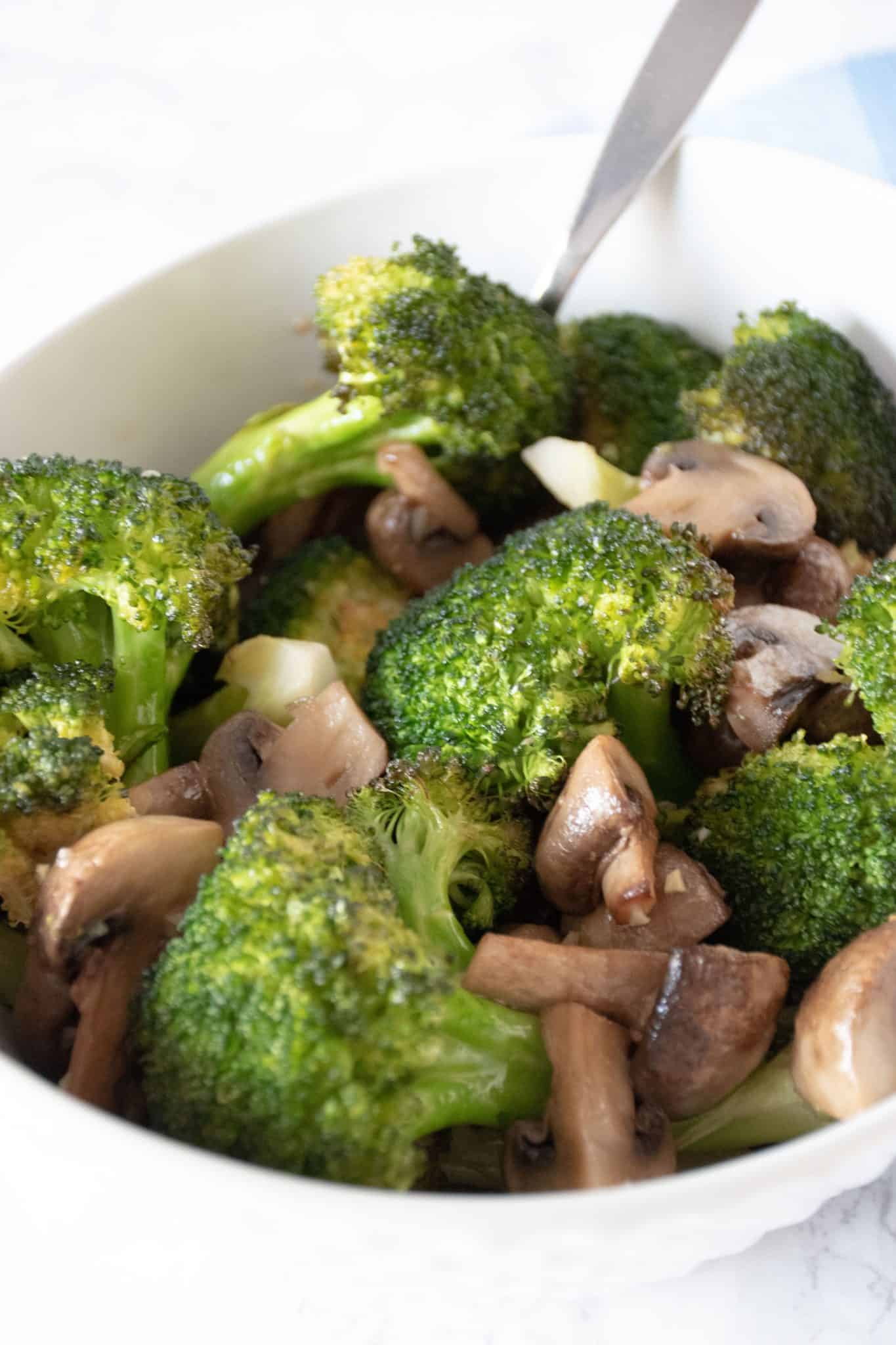 Roasted broccoli and mushrooms in a bowl.