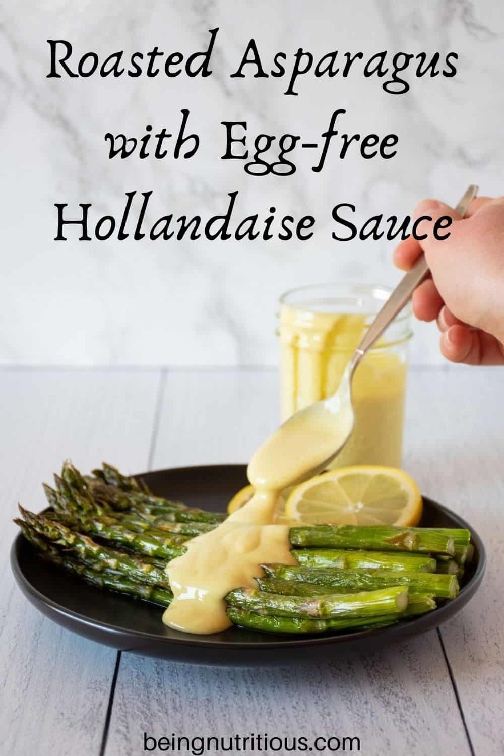 Plate of roasted asparagus being drizzled with sauce. Text overlay: Roasted Asparagus with Egg free Hollandaise Sauce.