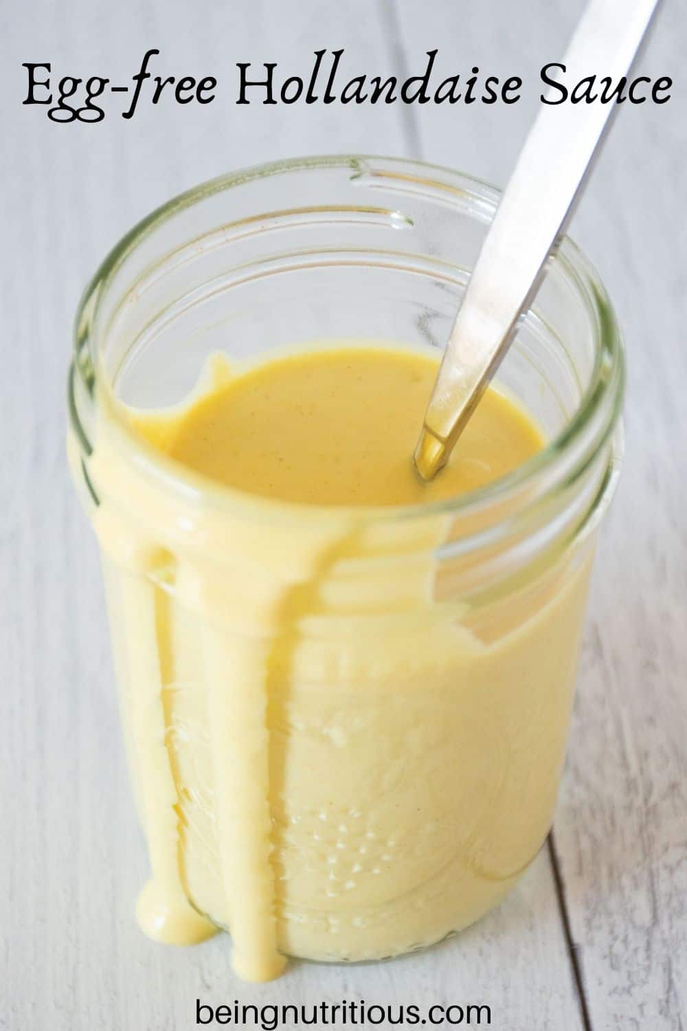 Jar of sauce with a spoon in it. Text overlay: Egg-free Hollandaise Sauce.