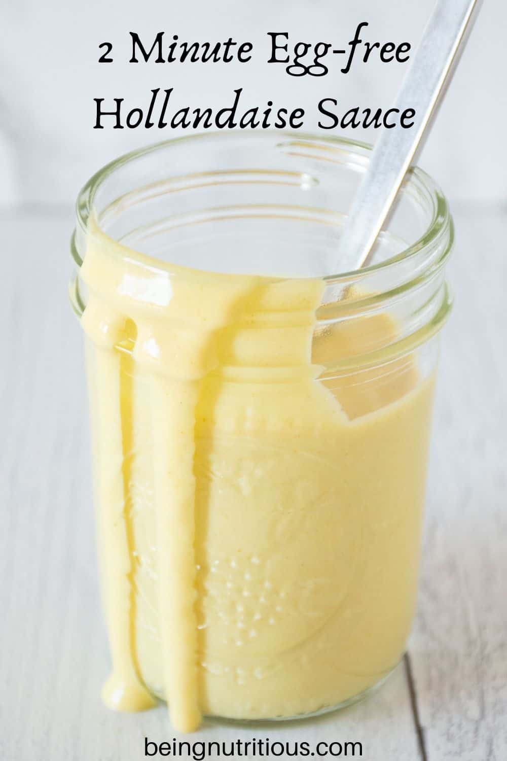 Jar of sauce with a spoon in it. Text overlay: 2 Minute Egg-free Hollandaise Sauce.